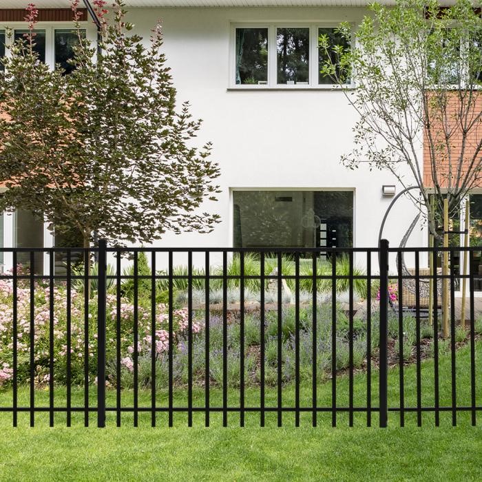 aluminum-fence-outside-home A black aluminum fence outside a home with trees and other foliage in the yard.