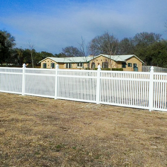 closed-top-picket A closed top picket fence with Gothic fence caps surrounds a home and property.
