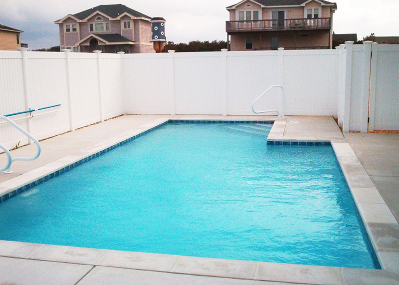 pool-fence-1 A large swimming pool is surrounded by a privacy fence.